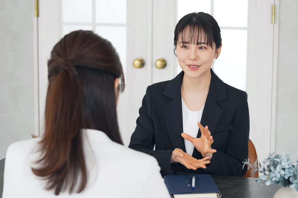 女性相談員が相談者の話を丁寧に聞いている面談風景