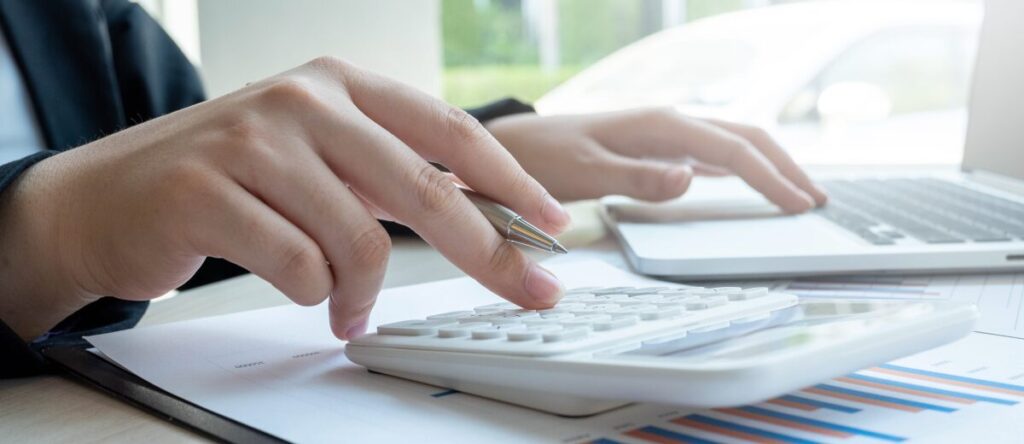 電卓と資料を使って調査料金を確認する様子